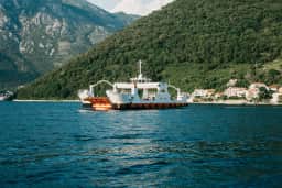 The Lepetane ferry, the vessel that runs the Kamenari crossing, on the water at the narrows of the Bay of Kotor.