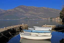 Small boats moored beside a stone waterfront in Bijela