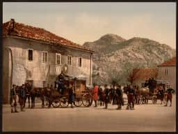 Un fotocromo colorato a mano degli anni Novanta dell'Ottocento raffigura Cetinje: la città dell'epoca reale, fatta di bassi edifici bianchi, nella sua spoglia valle di montagna.