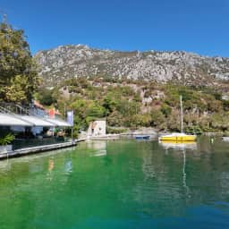 The green water of the mill cove at Morinj, boats moored below the restaurant terrace