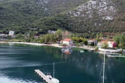 Selo Morinj na obali unutrašnjeg dijela Bokokotorskog zaliva, sa kućama smještenim između vode i strmih pošumljenih padina.