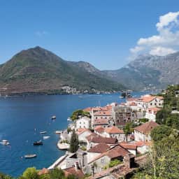 Red tiled rooftops of Perast in the foreground with the Bay of Kotor stretching out behind them.