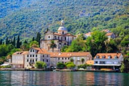 Kupola crkve Rođenja Bogorodice uzdiže se nad kućama na obali Prčnja