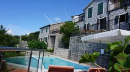 Restored stone accommodation buildings and pool in the Klinci 2014 gallery