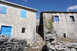 Case tradizionali in pietra con persiane azzurre a Žlijebi