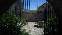 View through an iron grille and stone archway in Ulcinj Old Town