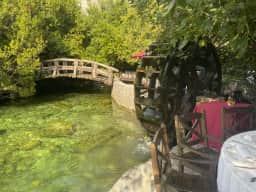 A wooden waterwheel beside a stone bridge over the mill race at Stari Mlini