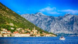 Baroque waterfront of Perast seen from the sea, with its bell tower and the two islets