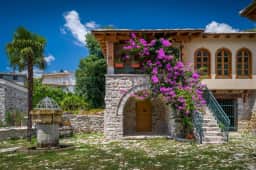 Restored stone house, courtyard fountain and bougainvillea inside Stari Bar