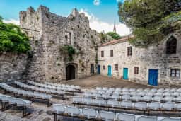 Open-air summer stage arranged among restored stone buildings in Stari Bar