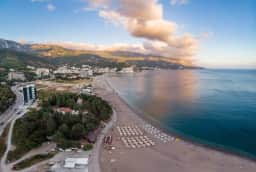 Veduta aerea lungo la spiaggia di Bečići in direzione di Rafailovići, con le montagne sullo sfondo