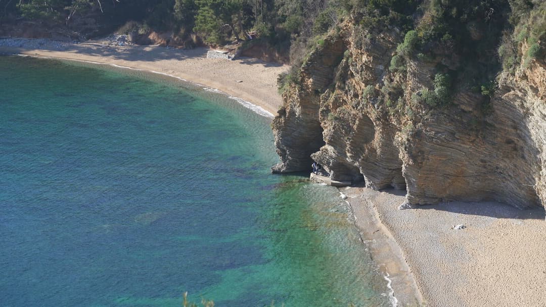 Mogren Beach seen from the cliffs with turquoise water and sandy shoreline