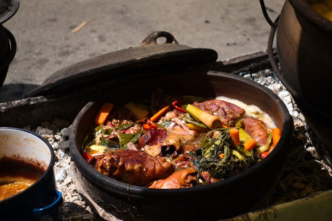 Traditional lamb and vegetables slow-cooked in a cast-iron pot over hot coals