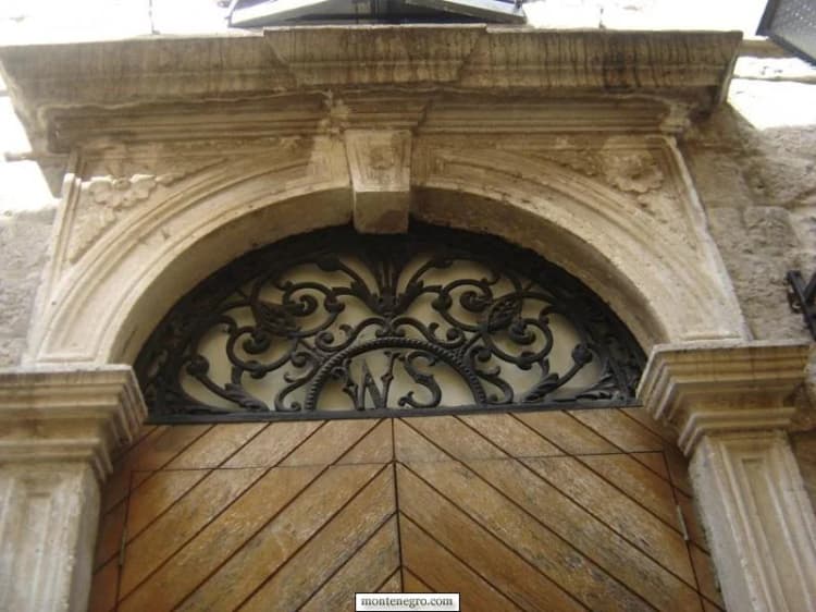 Portail de pierre sculptée, portes de bois et imposte en fer forgé photographiés à Herceg Novi