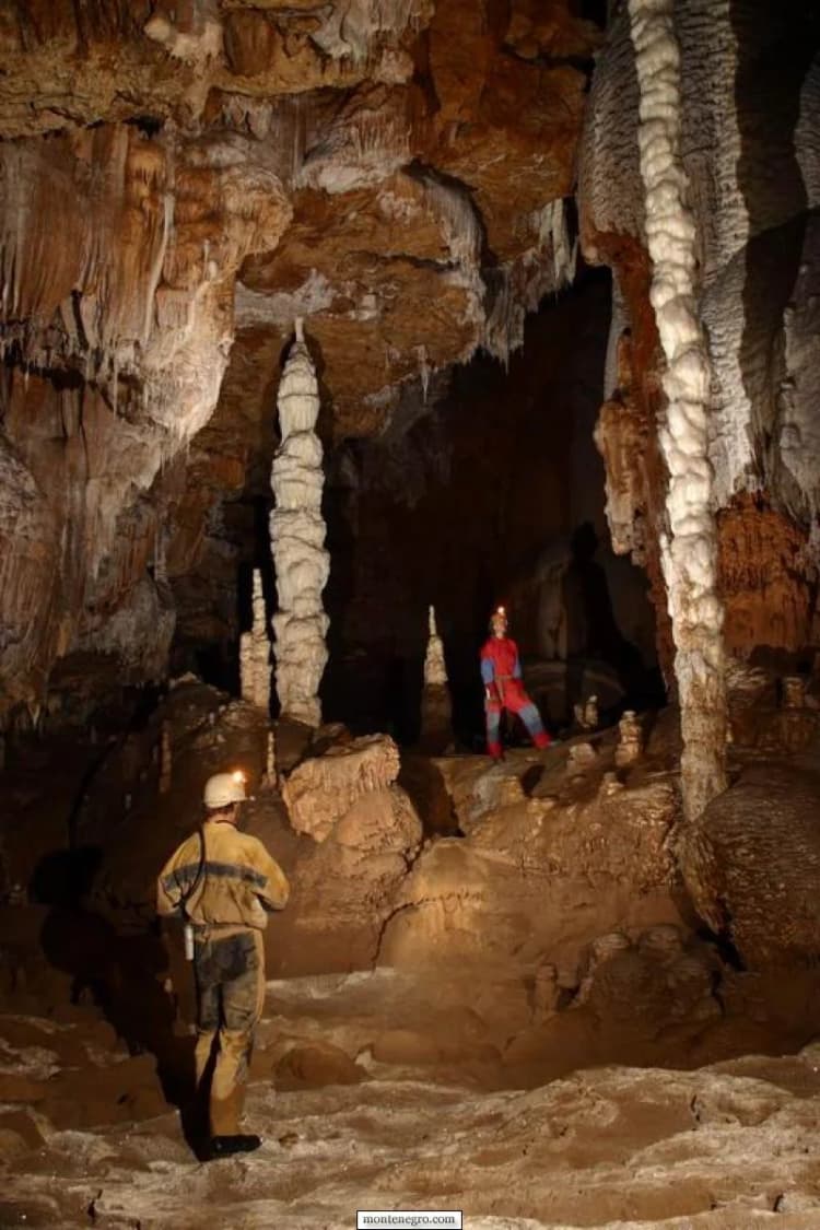 Caver standing among limestone walls in the Đalovića archive