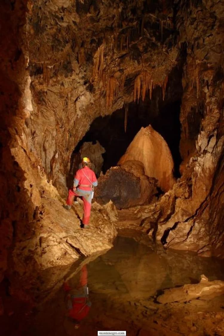 Caver examining rock surfaces in the Đalovića expedition archive