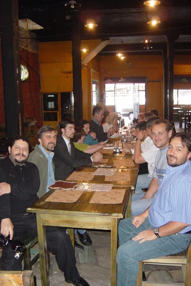 Group seated at a long table during an archival Montenegrin diaspora gathering in Argentina