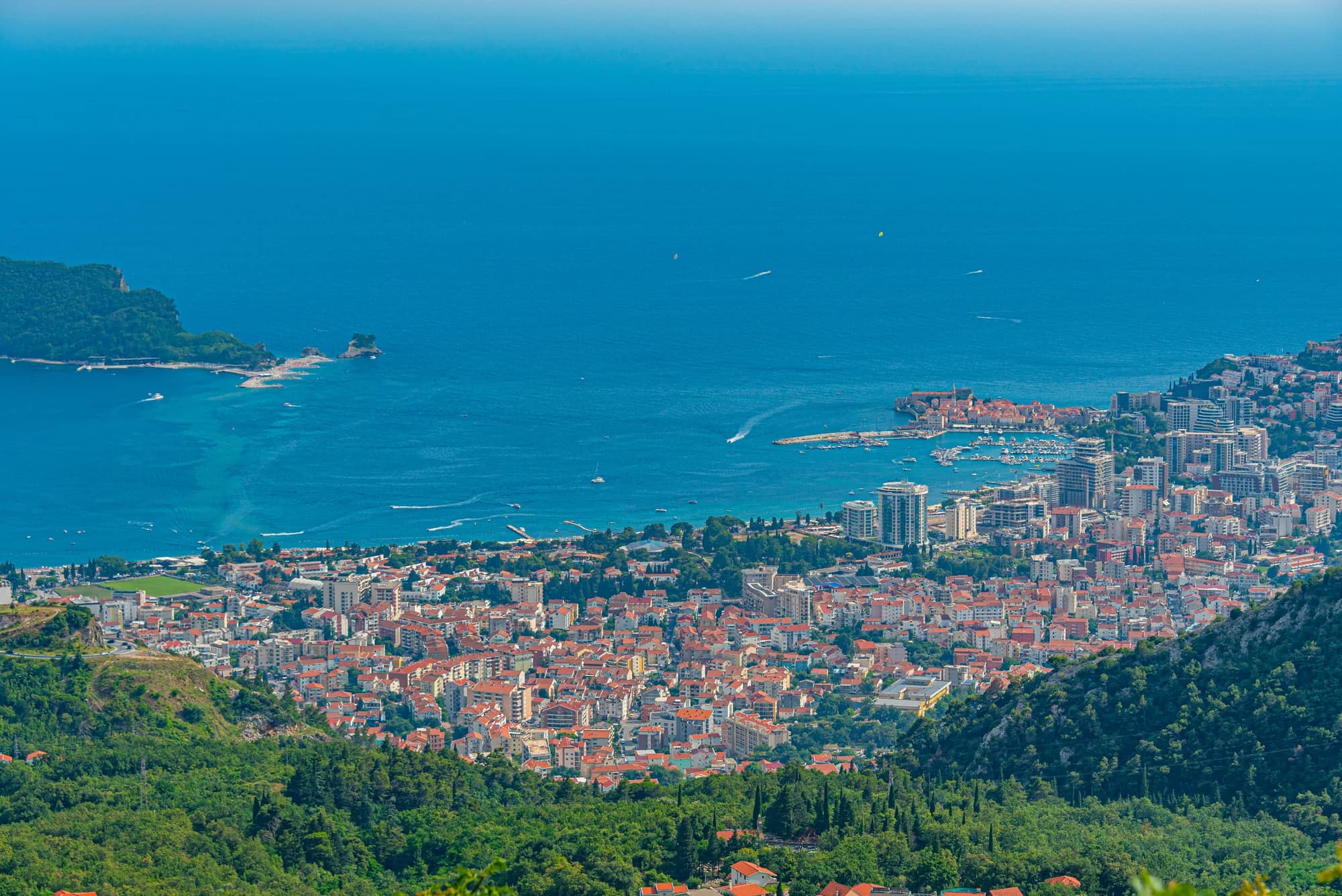The Bečići beach strip and hotels from the air, Sveti Nikola island beyond