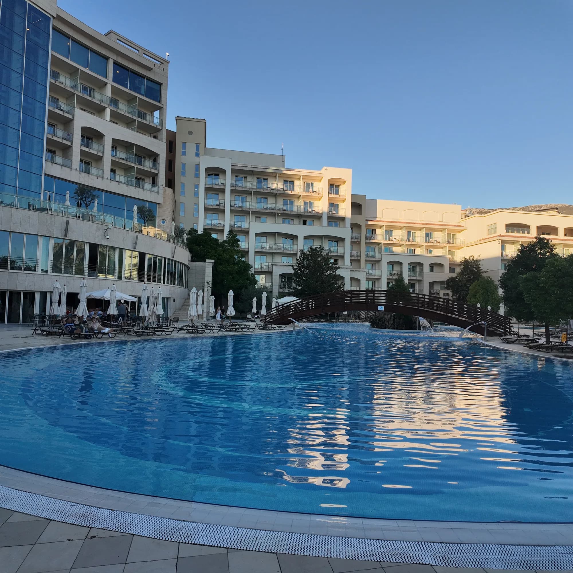 The pool of the Hotel Splendid at Bečići, its curved wings reflected in the water