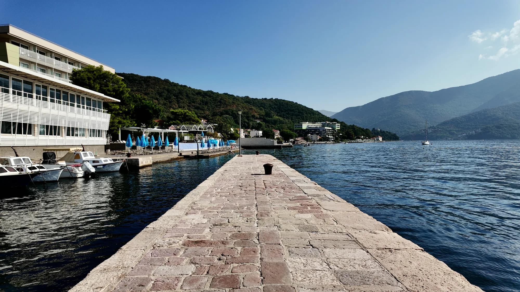 Ein steinerner Pier, der in die Bucht von Bijela hinausführt