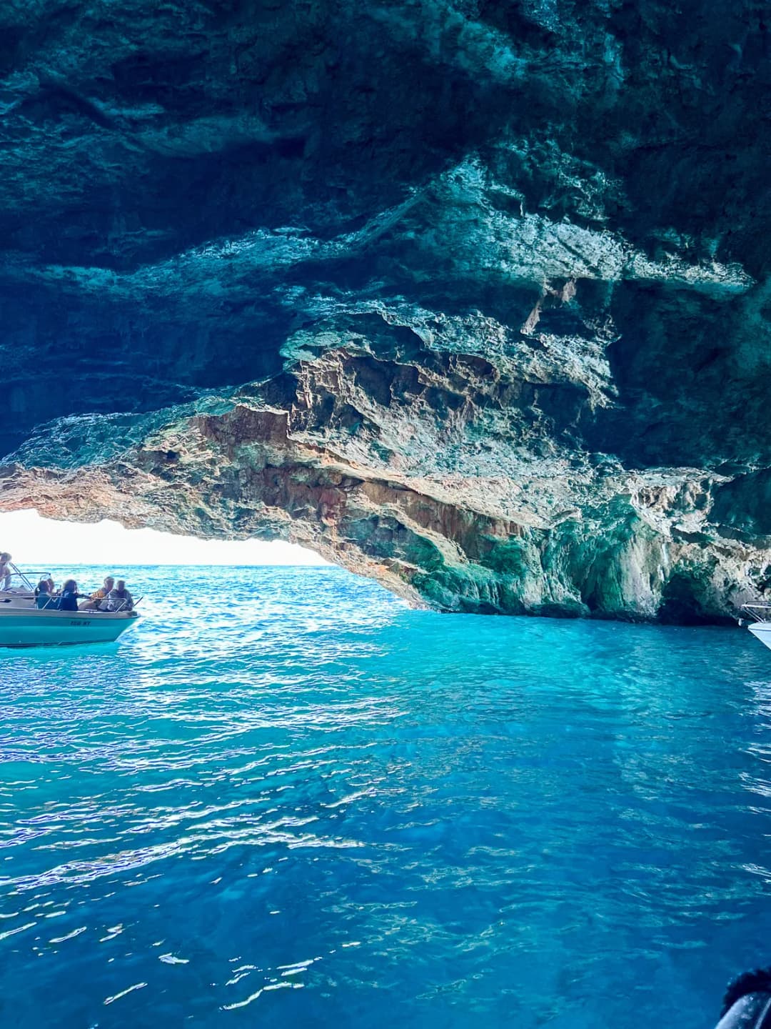 The mouth of the Blue Cave framing the open sea and the coastline beyond