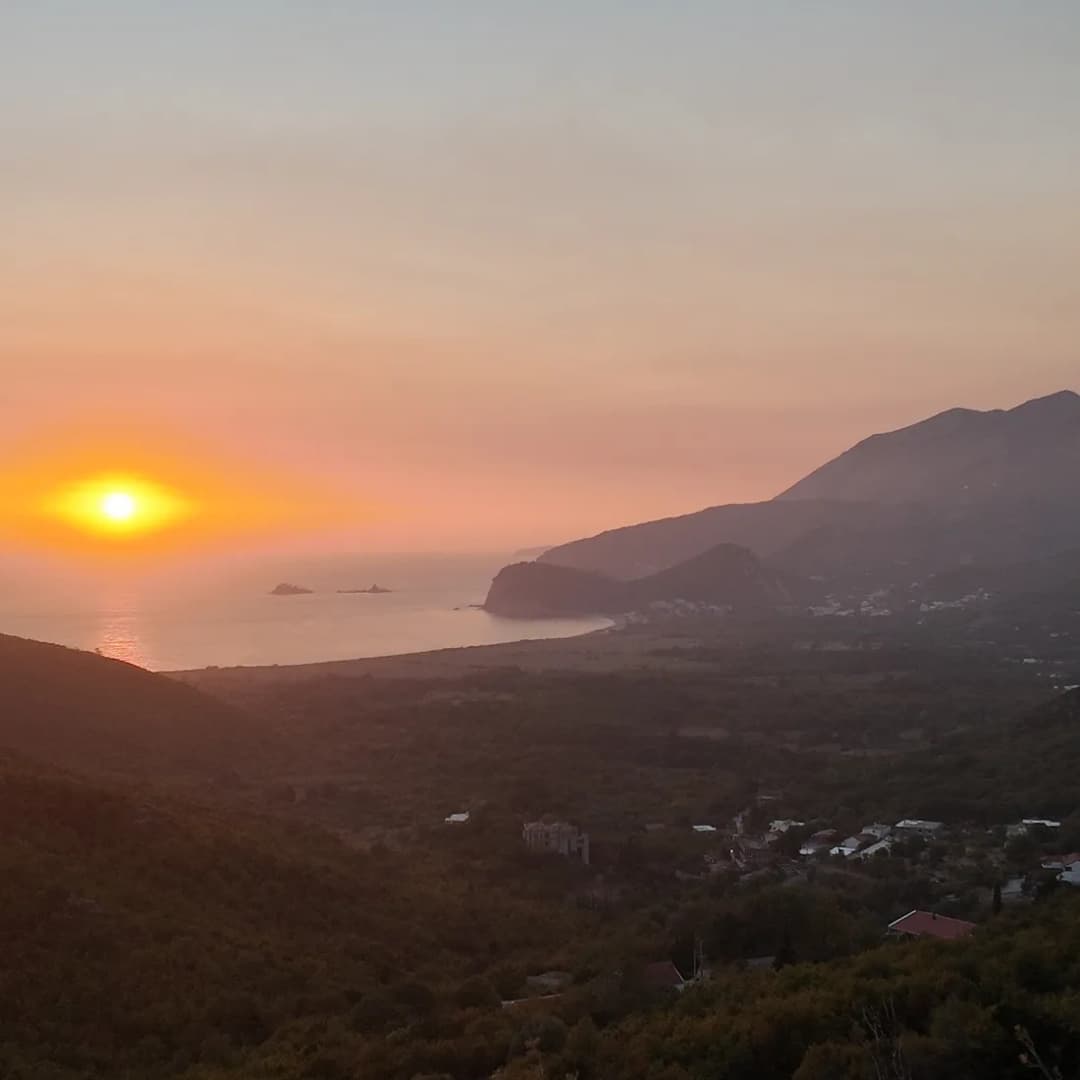 The sun setting across the wide bay at Buljarica.