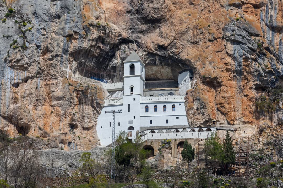 The Upper Monastery at Ostrog, with the terrace opening out above the wooded slopes falling away toward the Bjelopavlići plain.