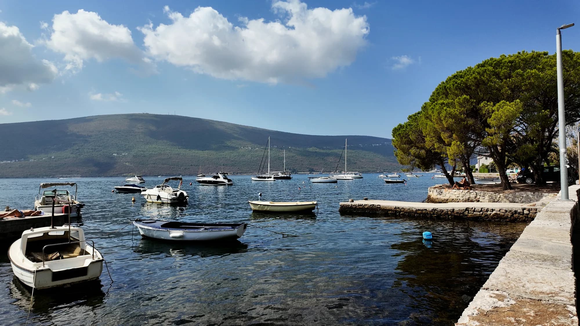 Small boats at the shore at Đenovići, the far side of the bay behind