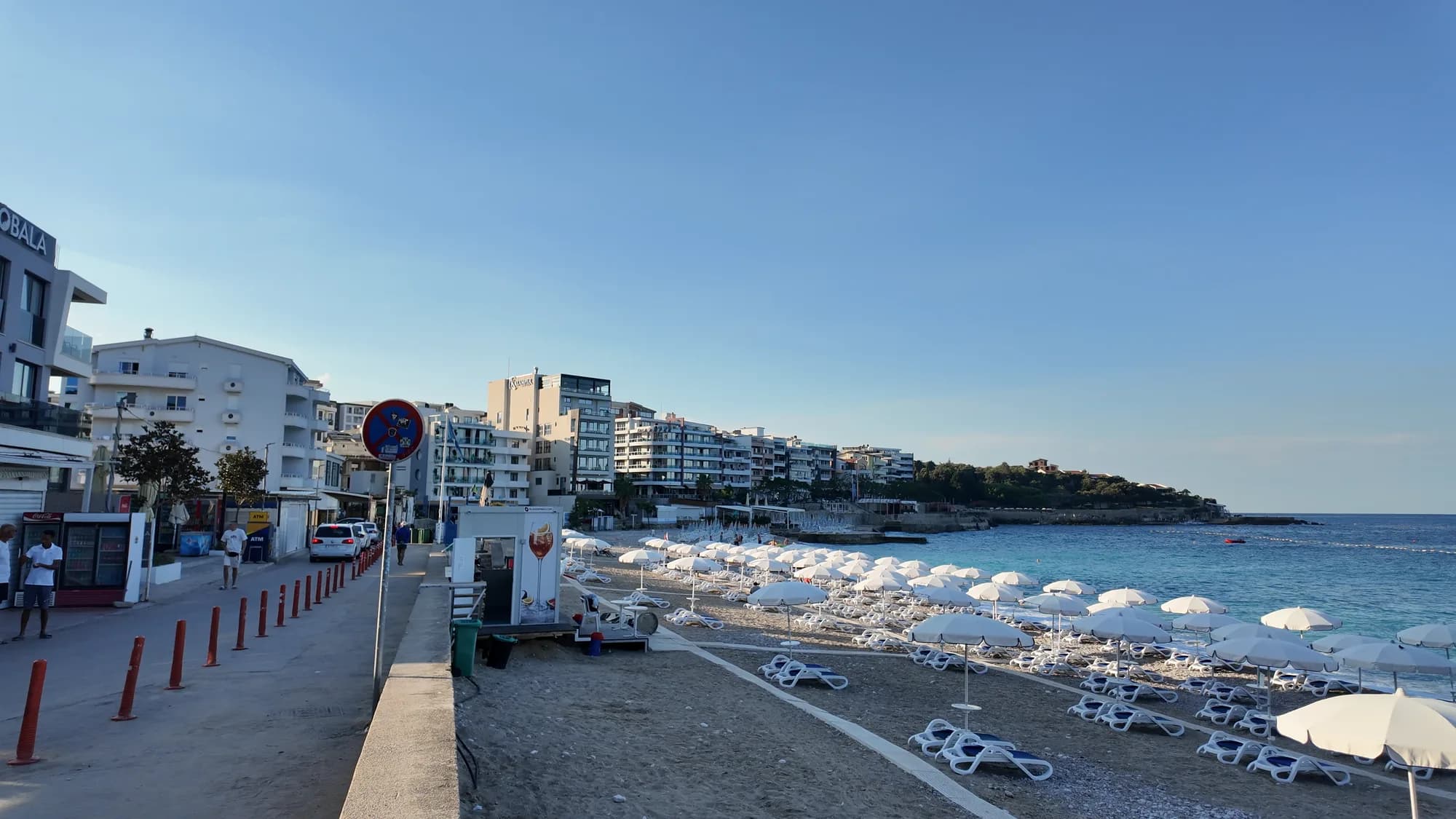 The promenade behind Veliki Pijesak, cafés on one side and parasols on the shingle on the other