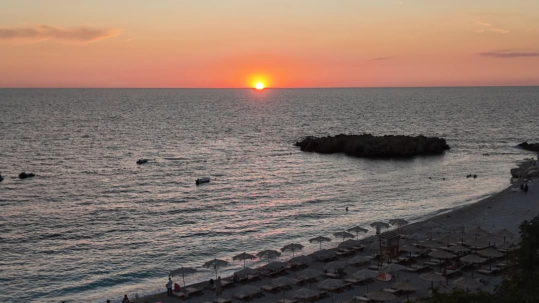The sun meeting the Adriatic horizon above Veliki Kamen and the curve of the beach at Veliki Pijesak