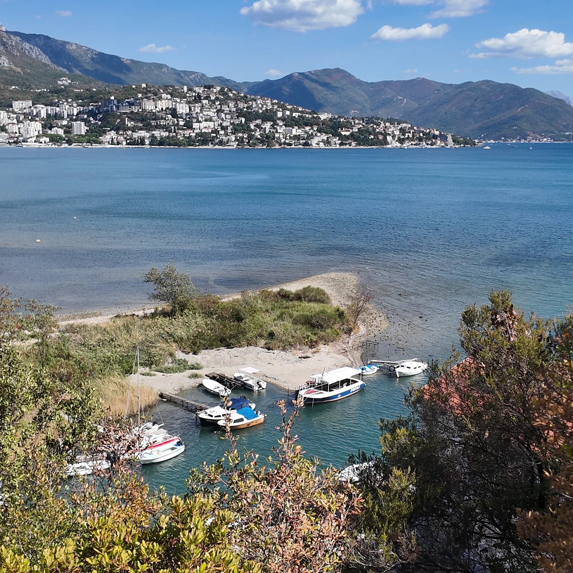 Small boats moored in the Stara Banja cove at the mouth of the Sutorina, the old spa shore where the mud lies