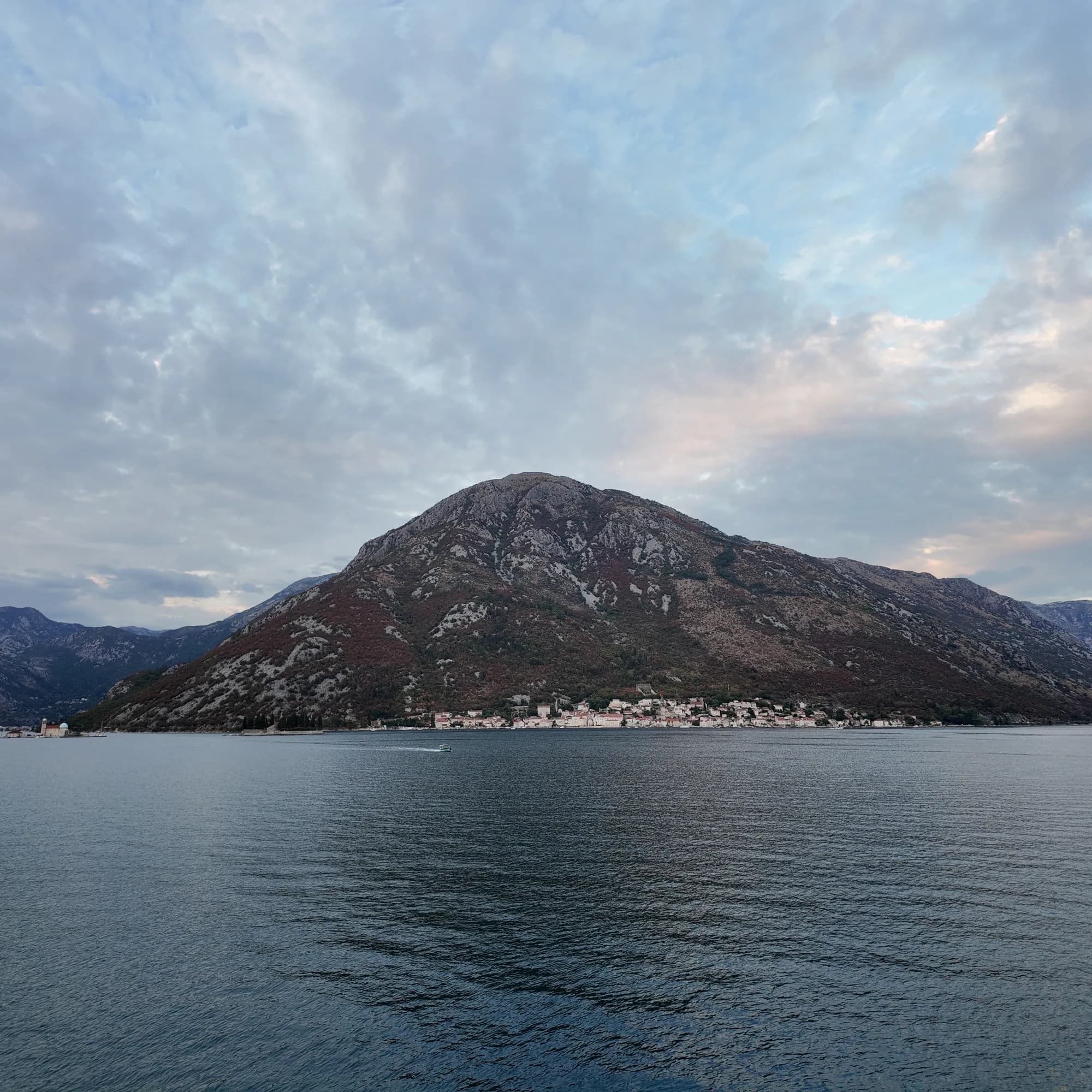 Evening sky over Perast and its mountain, the strait calm below