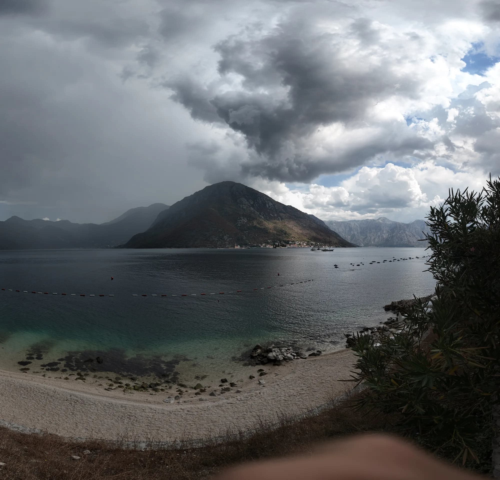 The shingle beach at Kostanjica under the storm, mussel-farm buoys in the strait