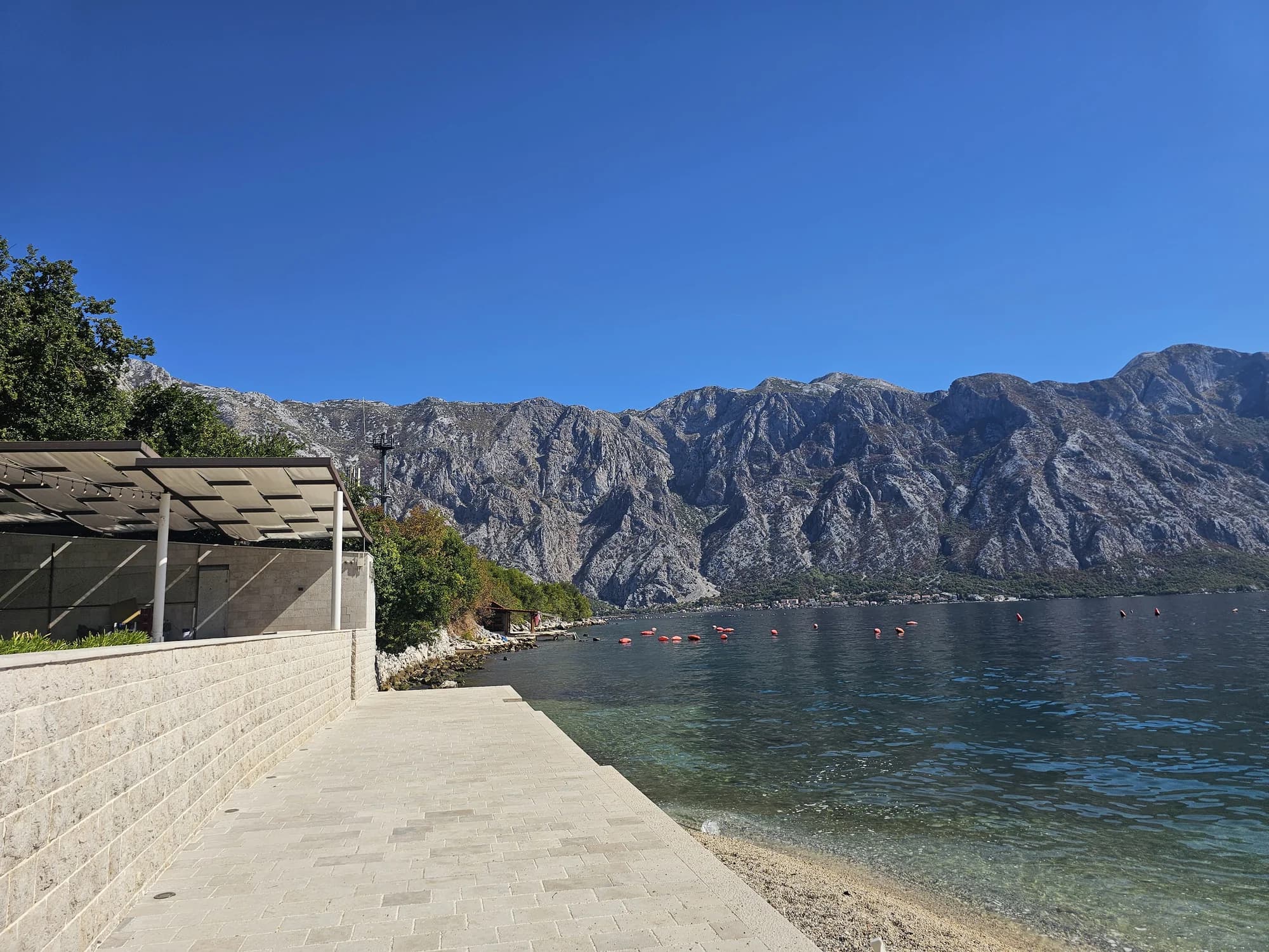 The stone swimming platform and buoyed water at Bajova Kula below the steep Boka mountains