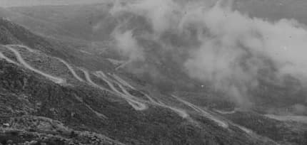 The Austrian serpentine road above Kotor around 1900: hairpin bends climbing bare karst slopes, photographed on a glass slide