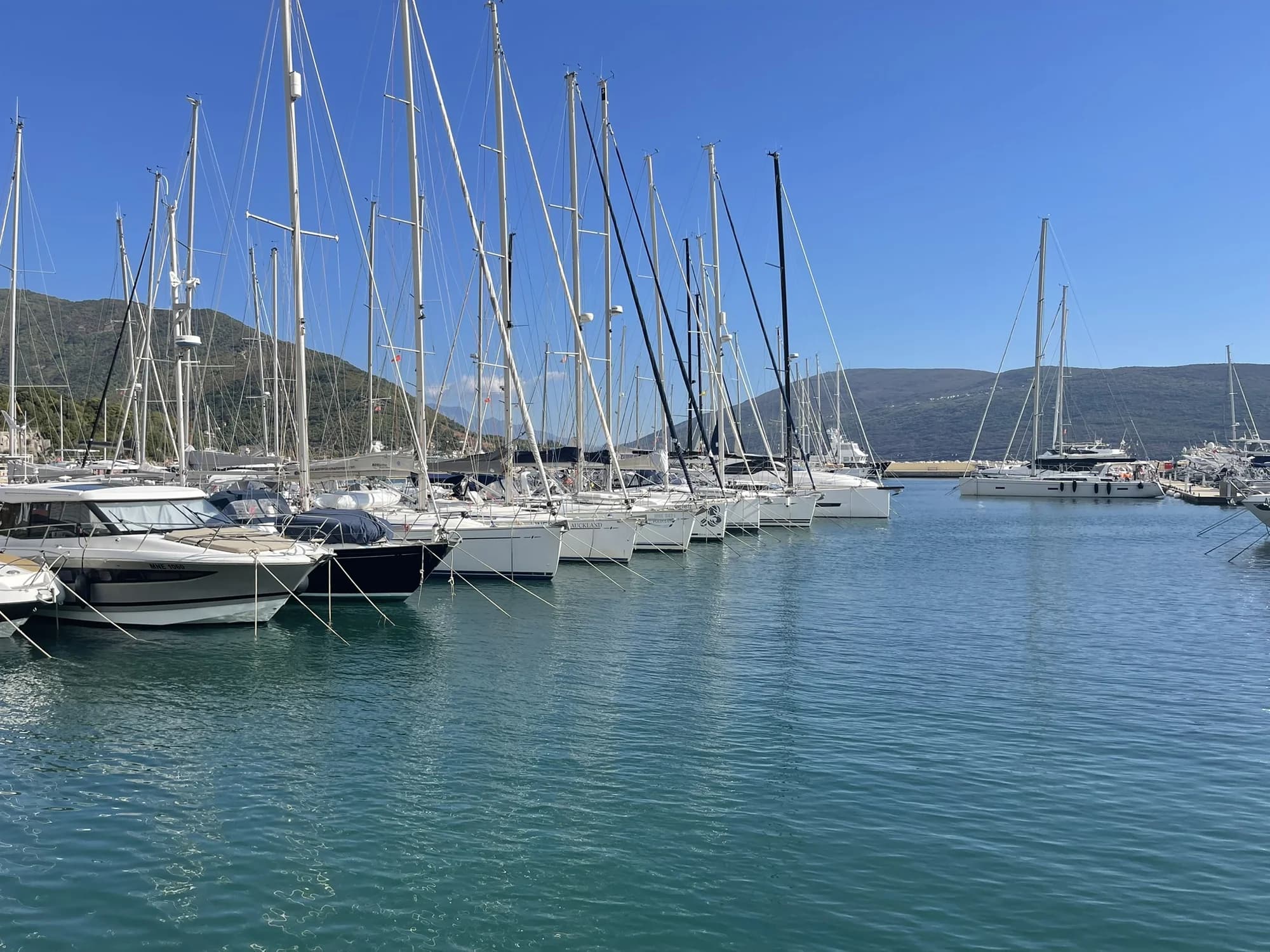 Sailing boats in Lazure marina beside Meljine Beach, backed by the green slopes above the bay