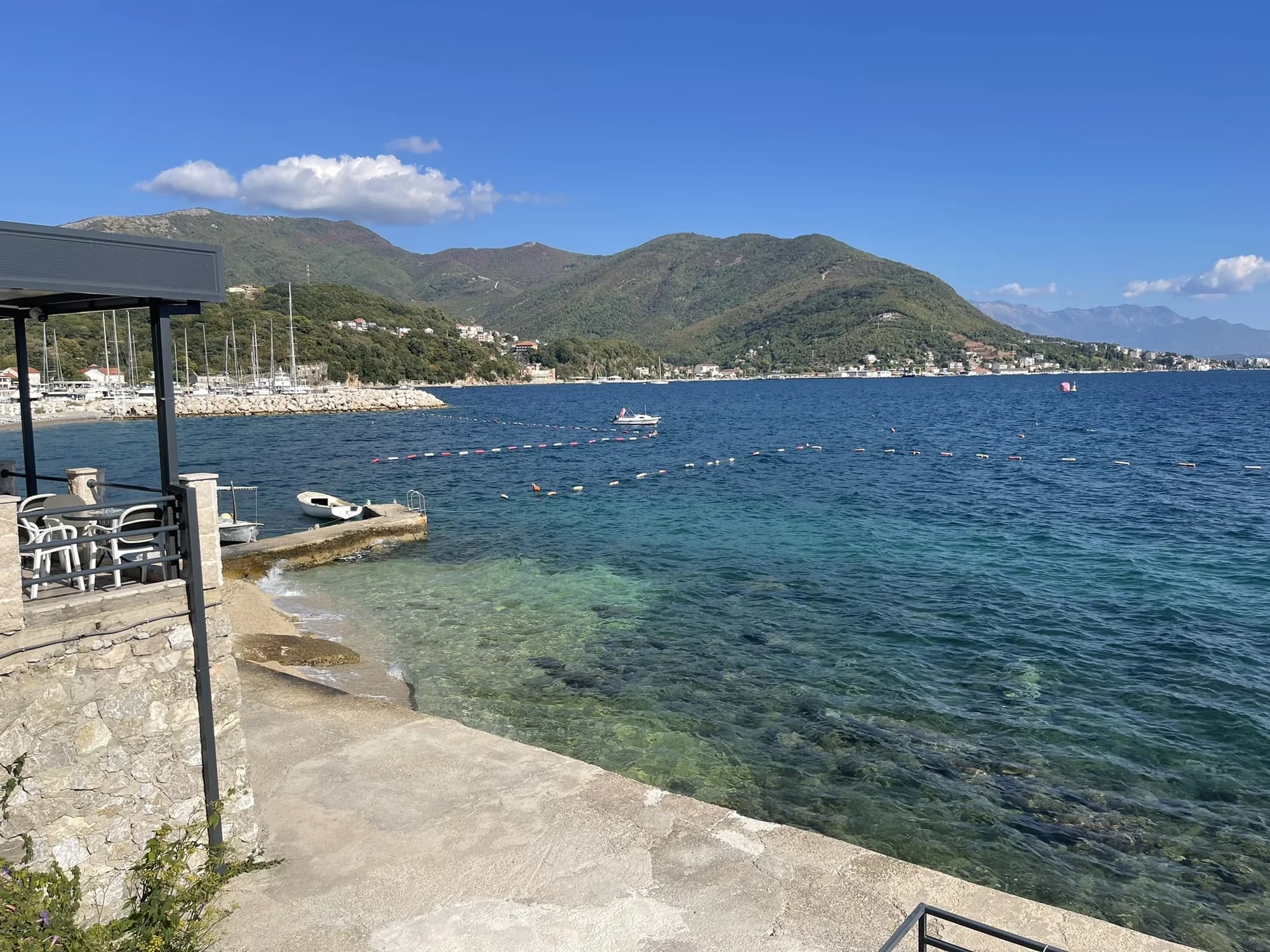 Clear water at the edge of Meljine Beach, the swimming zone and mountain shore beyond