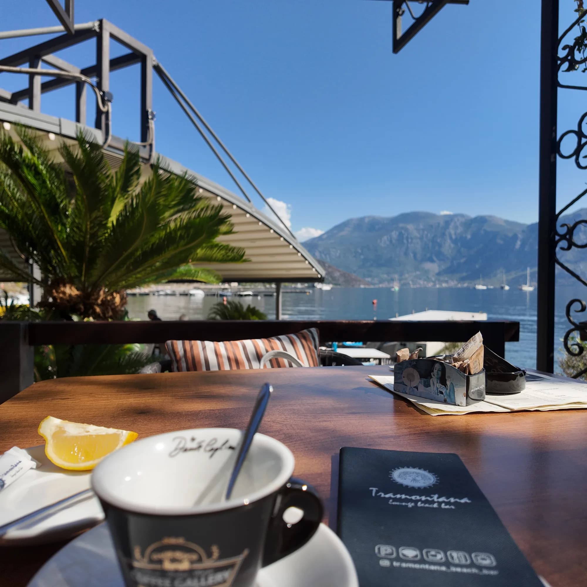 Coffee on a waterside terrace at Morinj, the bay and the mountains beyond the railing