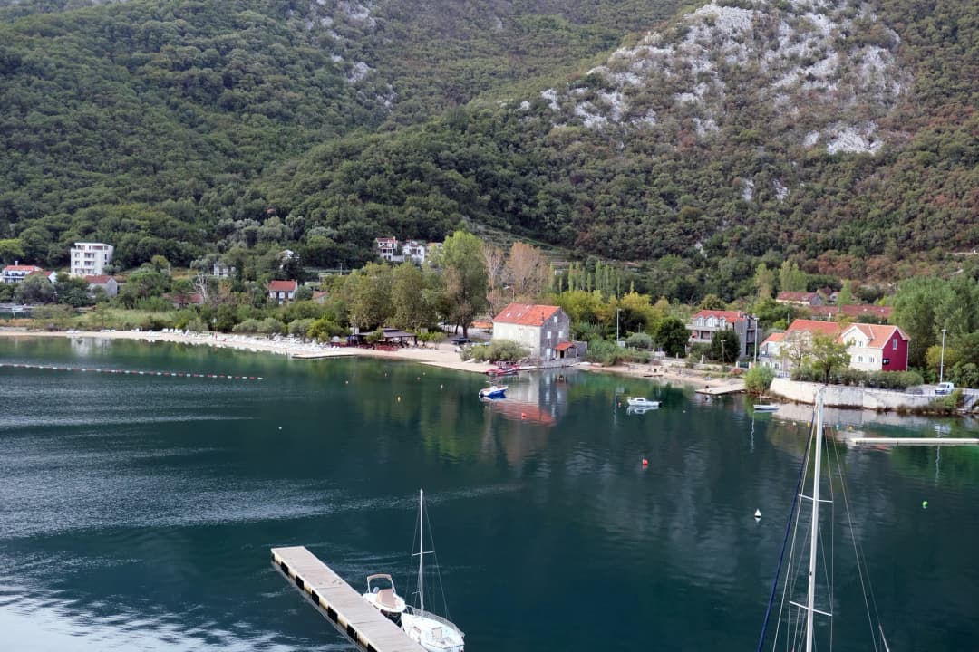 The shoreline at Morinj, the neighbouring village to Lipci, where stone houses and greenery meet the calm inner waters of the Bay of Kotor beneath steep mountains