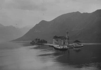 Die Inselchen vor Perast um 1900: im Vordergrund Gospa od Škrpjela mit Kapelle und Glockenturm, dahinter die bewaldete Insel Sveti Đorđe – eine Glasplattenaufnahme vom Ufer von Perast aus