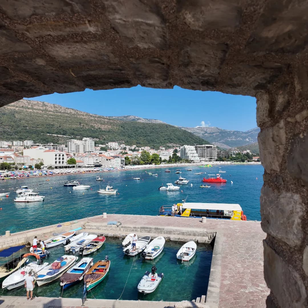A stone archway in the fortress framing the marina beyond.