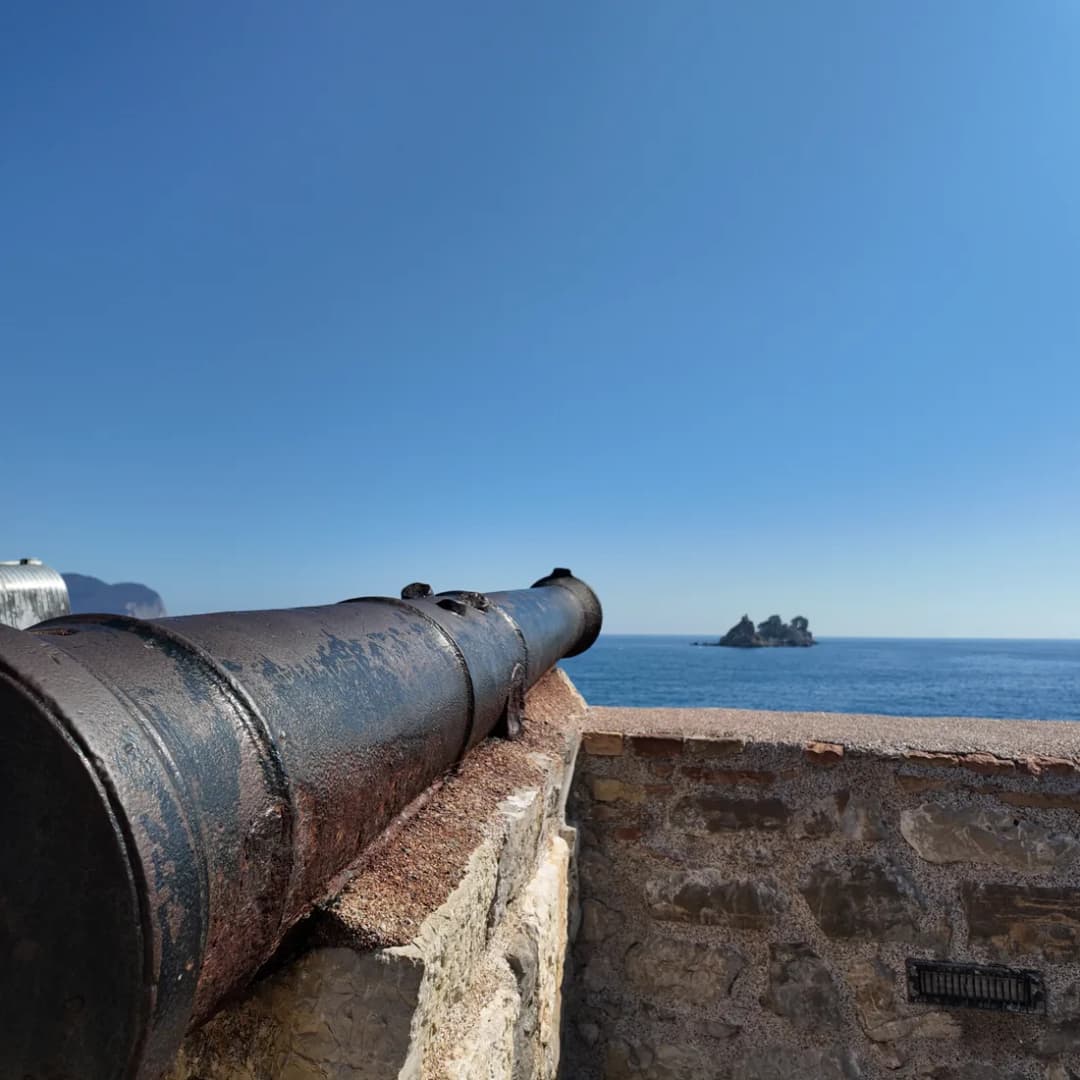 A cannon on the fortress terrace pointing out over open sea.