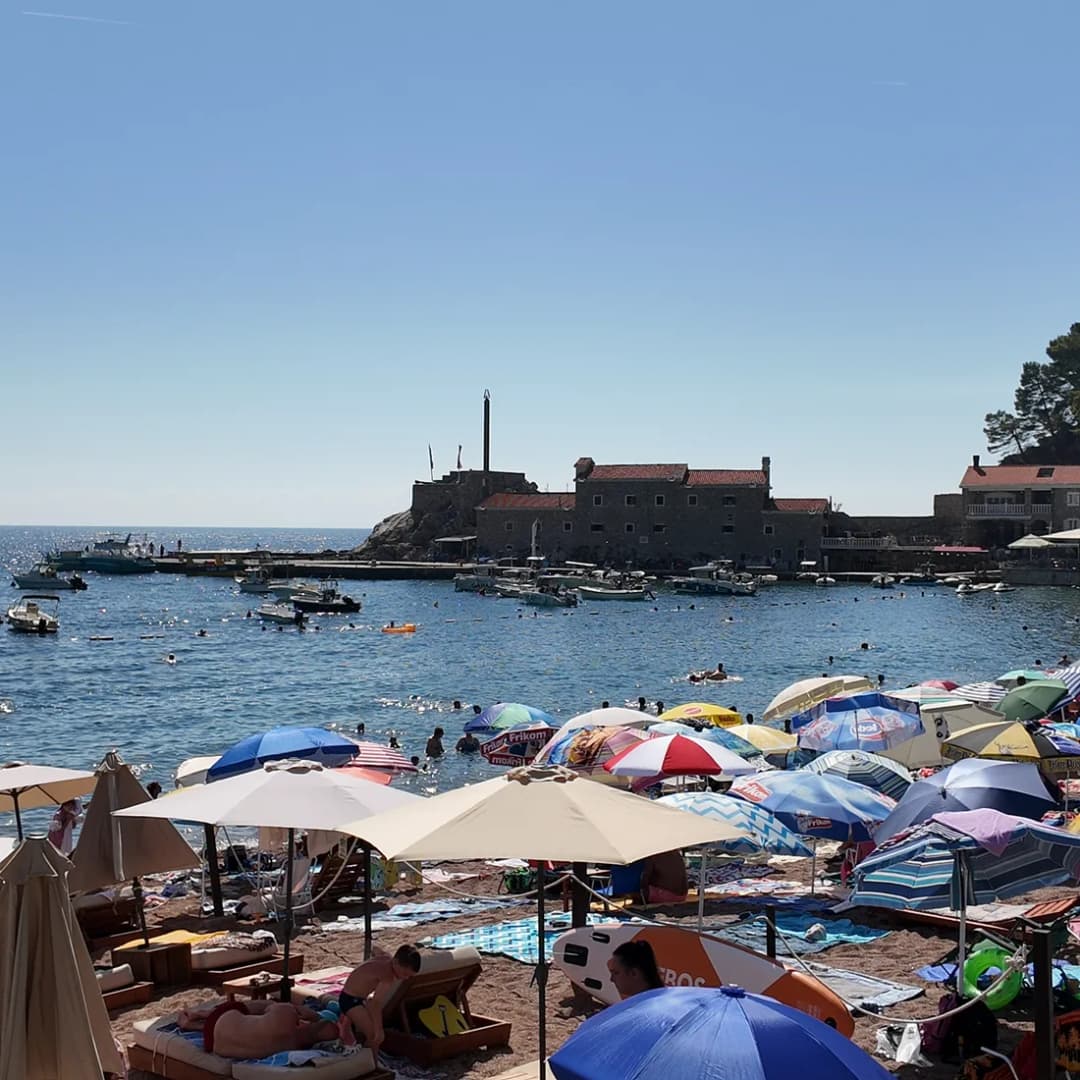 The stone Castello fortress seen from beach level at the end of the shoreline.