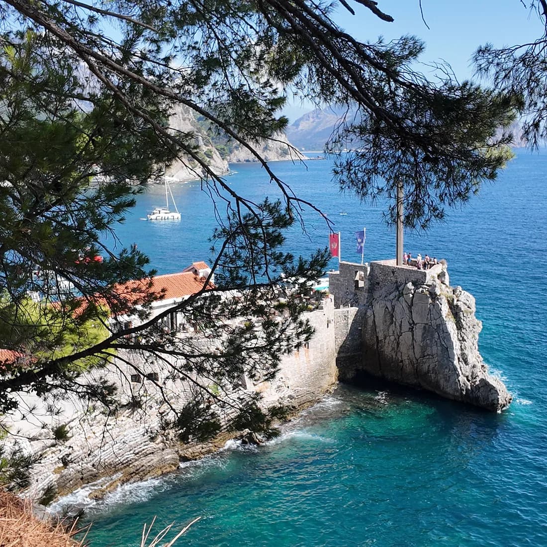 The Castello fortress on its rock and the turquoise water below it at the harbour end of the beach