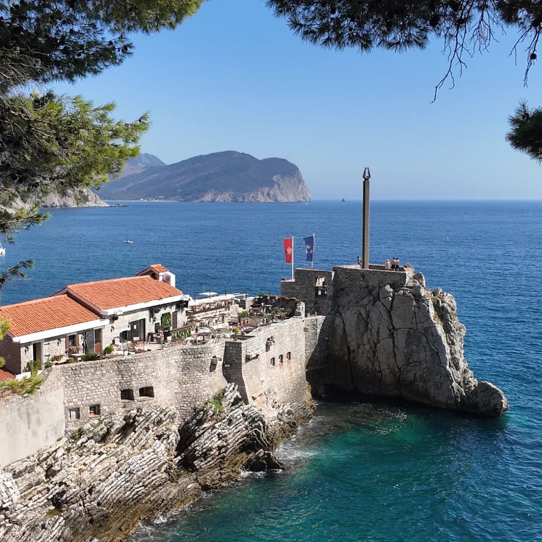 Fortress walls in the foreground with an islet visible out to sea.