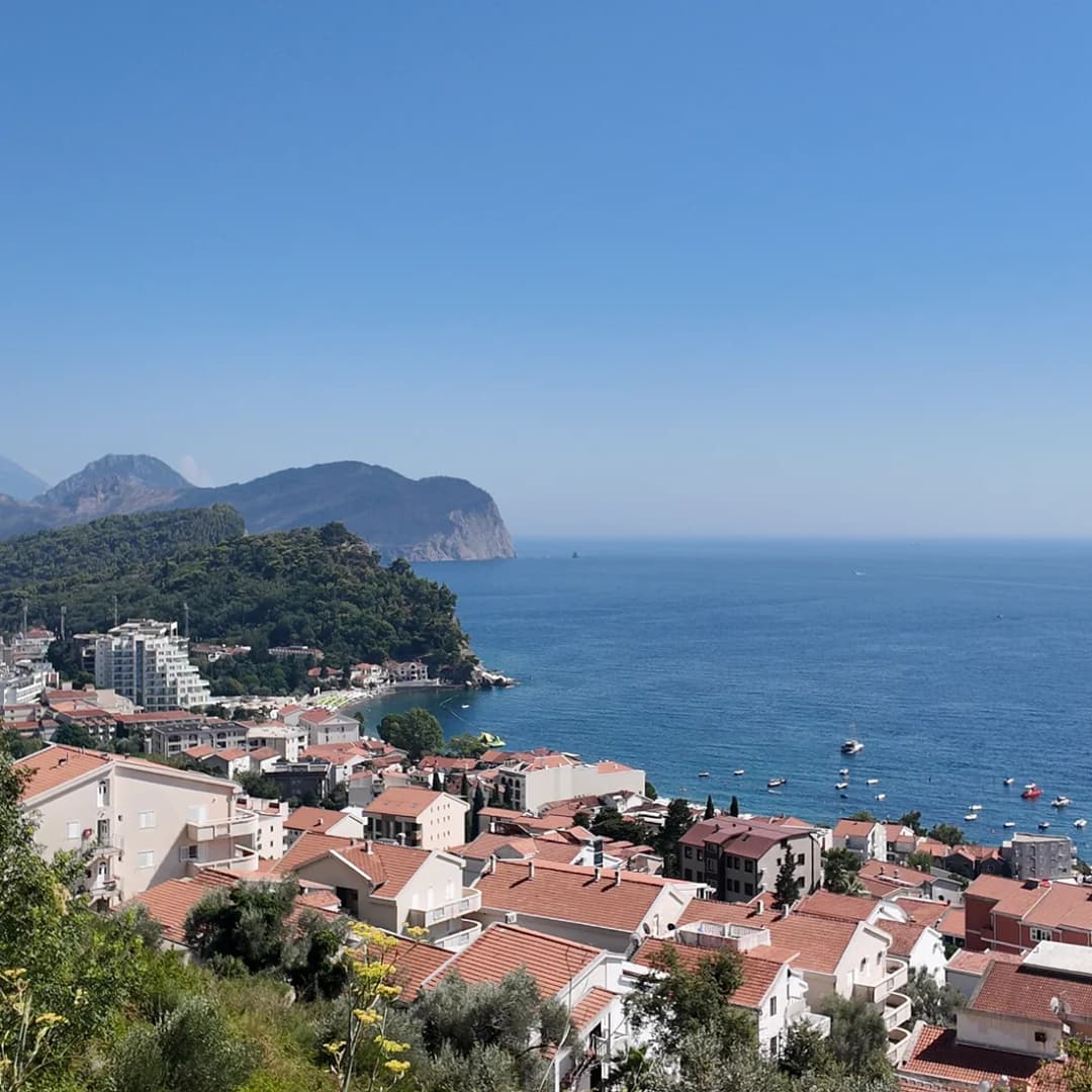 Red-tiled rooftops of Petrovac spread around the curve of its bay.