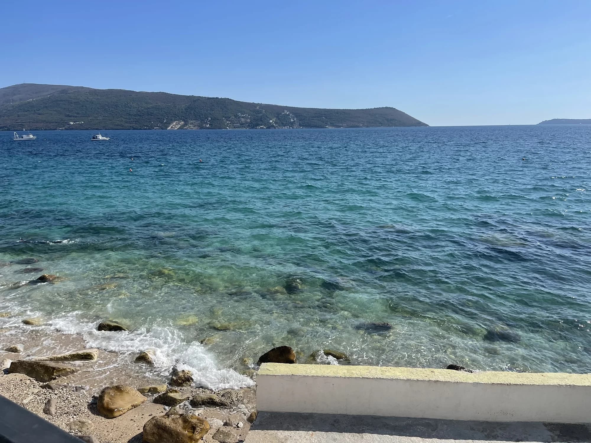 Clear turquoise shallows over stone and pebble on the Savina waterfront