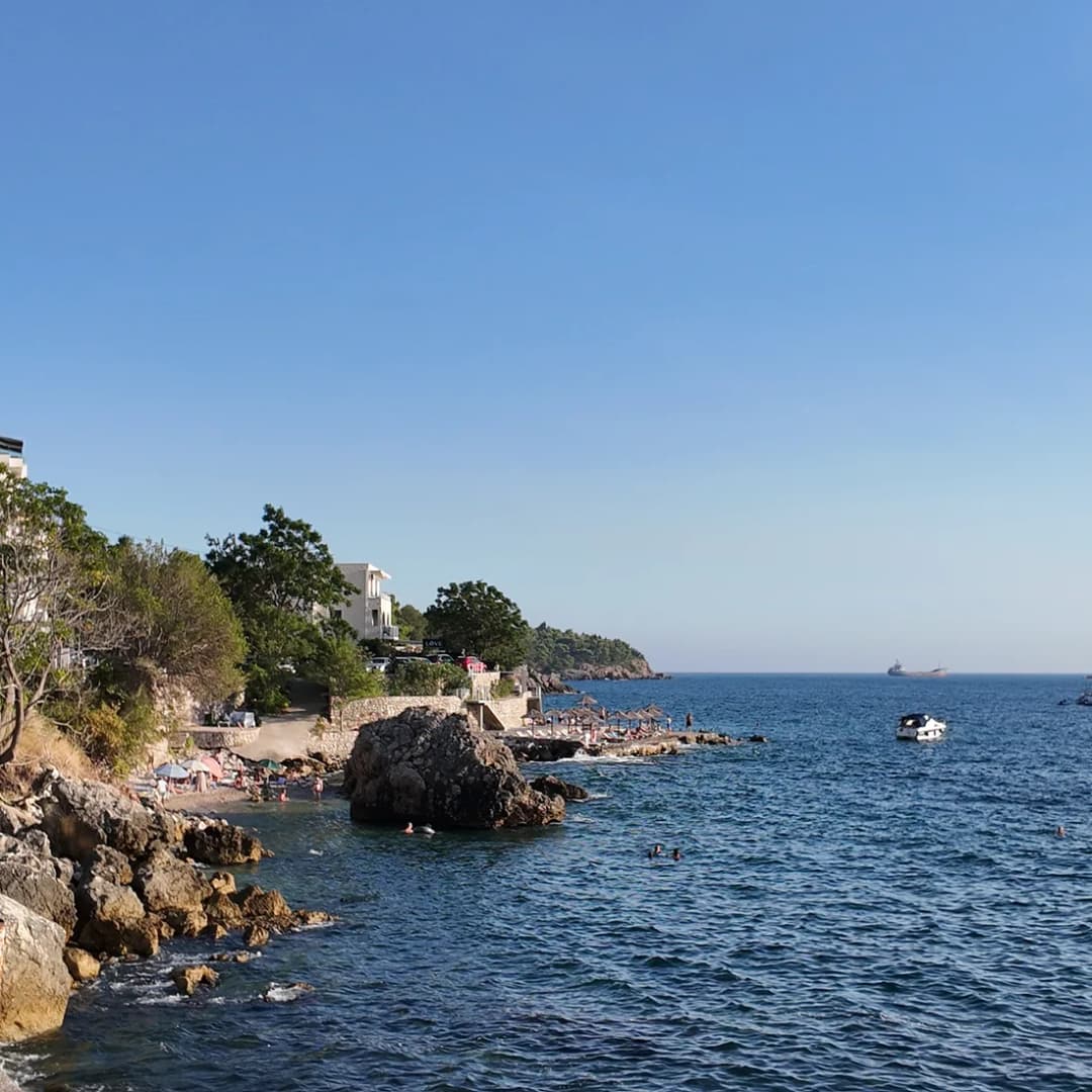 A rocky headland dropping into shallow, transparent water.