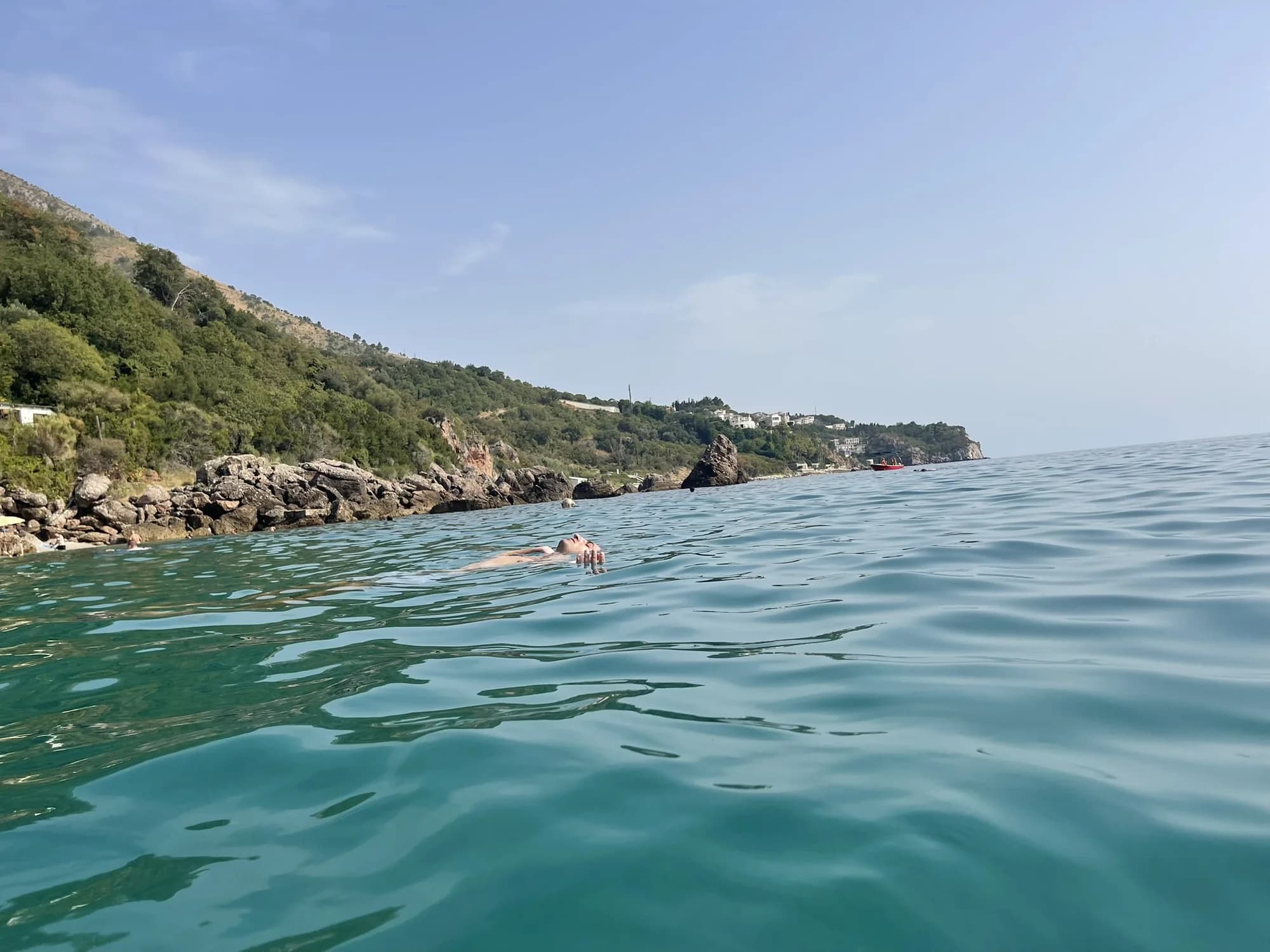 Drobni Pijesak seen from the water, the cove closed at both ends by rock and the coast running away to the south-east