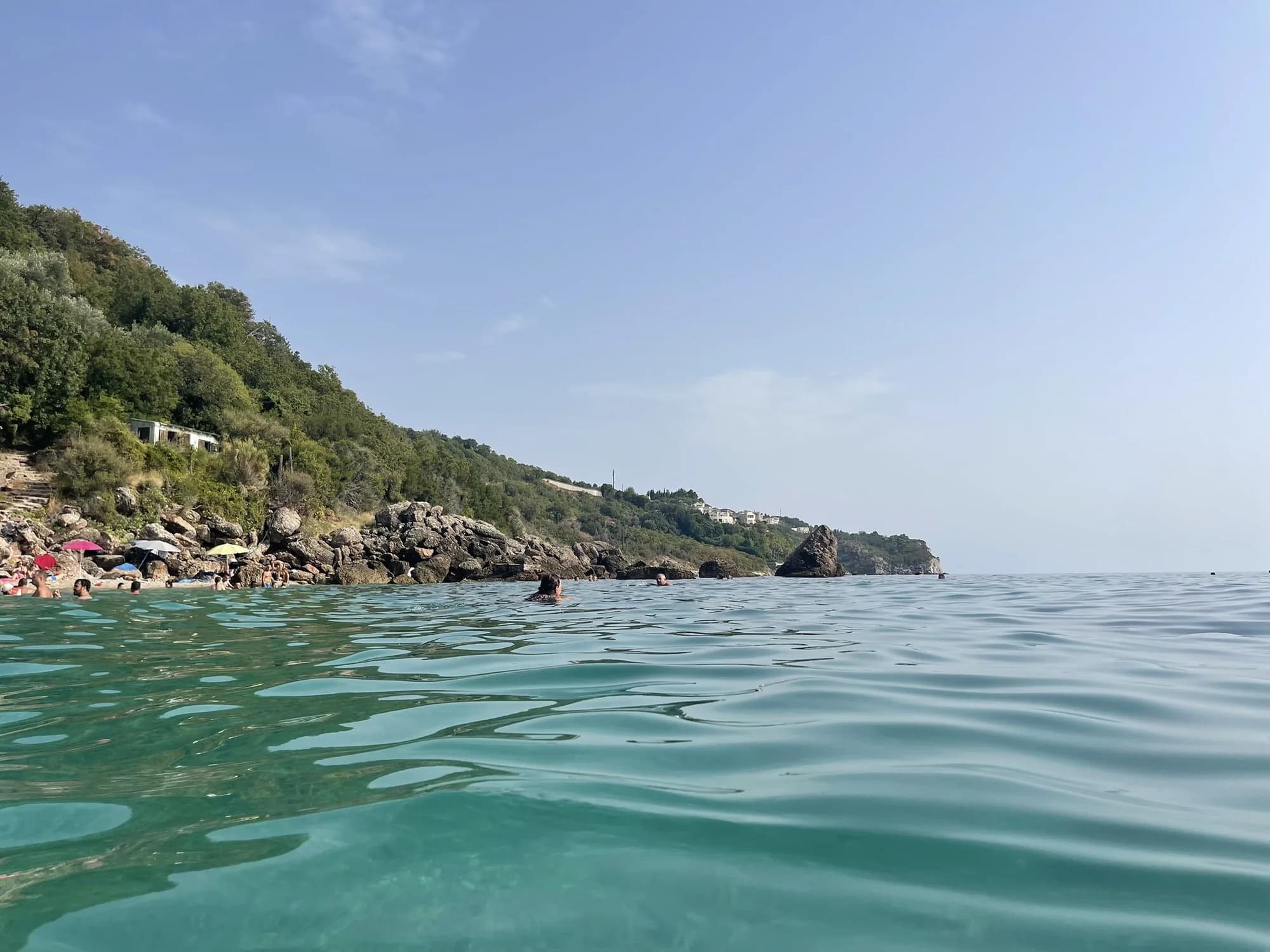 Clear turquoise water off Drobni Pijesak and the rocky headland that hides the cove from the road